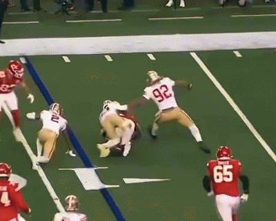 A Football Player Wearing A Number 97 Jersey Is Being Tackled By Another Player GIF