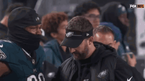 A Football Player Wearing A Number 98 Jersey Talks To A Coach GIF