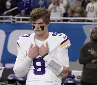 A Football Player Wearing A Purple And White Jersey With The Number 9 On It . GIF