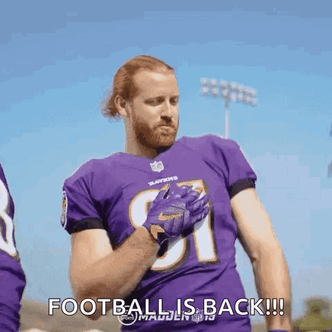 A Football Player Wearing A Purple Jersey And Gloves Is Standing On A Field And Says `` Football Is Back '' . GIF