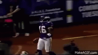 A Football Player Wearing A Purple Jersey And Helmet Is Running With A Ball On A Field . GIF