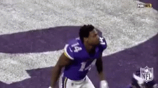 A Football Player Wearing A Purple Jersey With The Number 14 On It Is Jumping In The Air . GIF