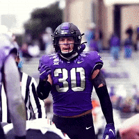 A Football Player Wearing A Purple Uniform With The Number 30 On It GIF