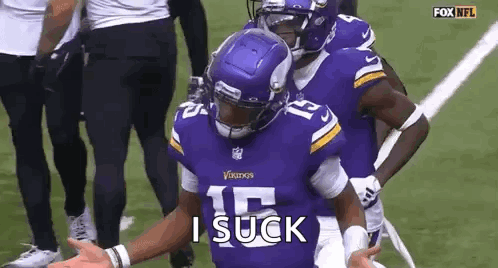 A Football Player Wearing A Purple Vikings Jersey Is Standing On A Field With His Arms Outstretched . GIF