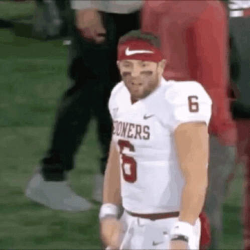 a football player wearing a red headband and a white jersey with the number 6 on it .