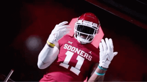 A Football Player Wearing A Red Jersey With The Number 11 On It Is Standing In A Tunnel . GIF