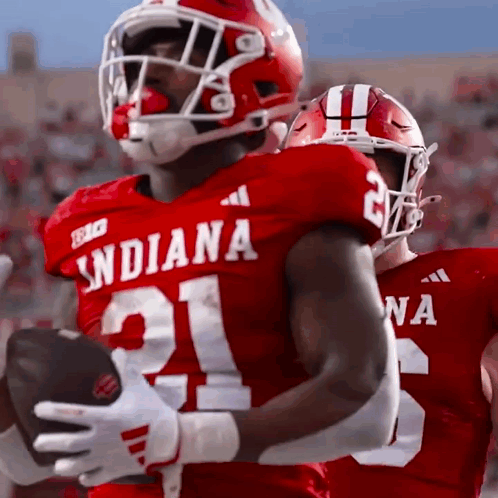 A Football Player Wearing A Red Jersey With The Number 21 On It GIF