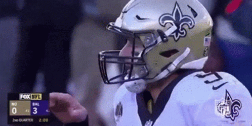 A Football Player Wearing A Saints Helmet Is Giving A Thumbs Up During A Game GIF