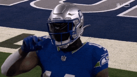 A Football Player Wearing A Seahawks Jersey And Helmet GIF