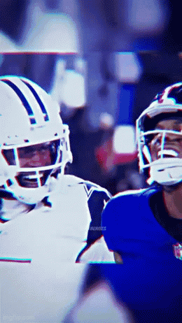 A Football Player Wearing A White Helmet Is Talking To Another Player Wearing A Blue Helmet GIF