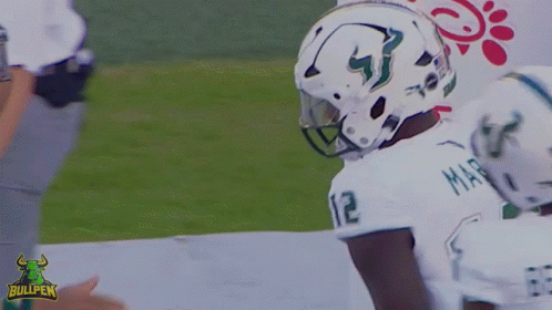 A Football Player Wearing A White Jersey With The Number 12 On It GIF