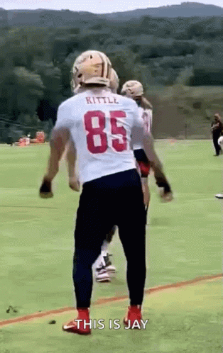 A Football Player Wearing A White Jersey With The Number 85 Is Standing On A Field . GIF