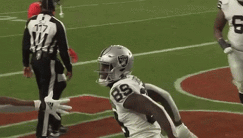 A Football Player Wearing A White Jersey With The Number 89 On It Is Standing On A Field . GIF