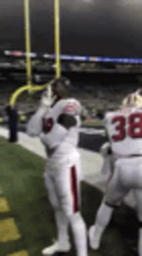 A Football Player Wearing A White Uniform With The Number 38 On It Is Standing On A Field . GIF