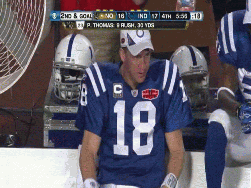 a football player wearing number 18 sits on the bench