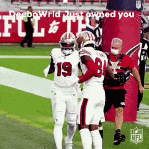 A Football Player Wearing Number 19 Is Hugging Another Player On The Field GIF