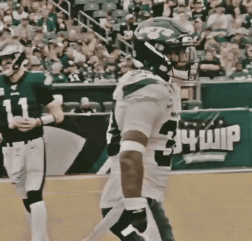 A Football Player Wearing Number 34 Whip Stands On The Field GIF