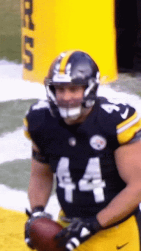 A Football Player Wearing Number 44 Holds A Football GIF