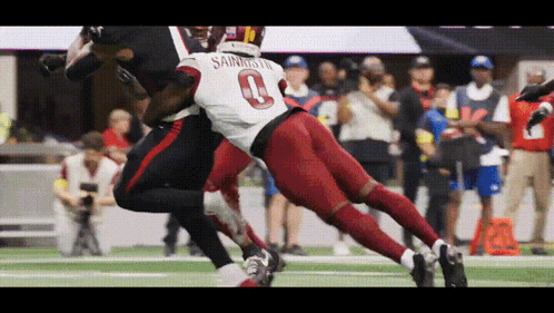A Football Player Wearing The Number 0 Jersey Is Being Tackled By Another Player GIF