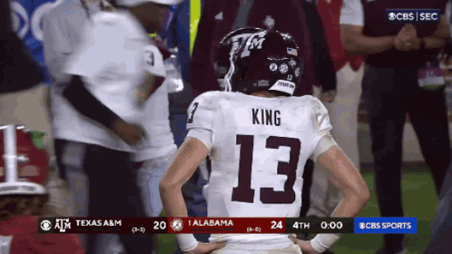 a football player wearing the number 13 stands on the field