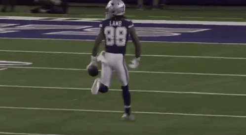 A Football Player Wearing The Number 98 Is Running On The Field . GIF