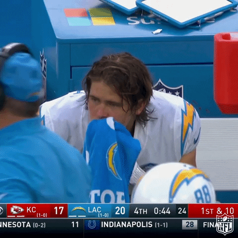 A Football Player Wipes His Nose With A Blue Towel During A Game GIF