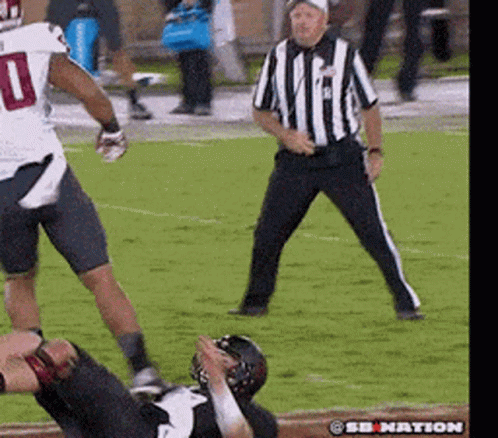 A Football Player With The Number 10 On His Jersey Is Being Tackled By Another Player GIF