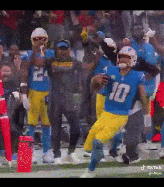 A Football Player With The Number 10 On His Jersey Is Running With The Ball GIF