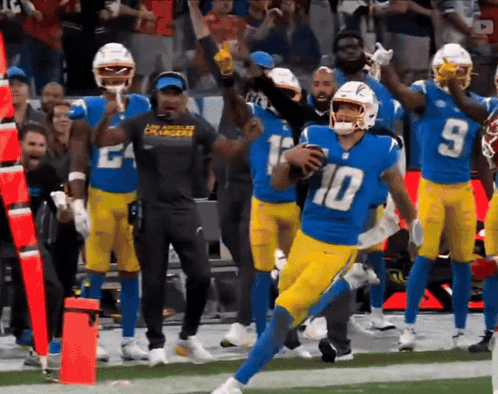 A Football Player With The Number 10 On His Jersey Runs With The Ball GIF
