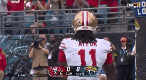 A Football Player With The Number 11 On His Jersey Stands In Front Of A Scoreboard . GIF