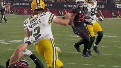 A Football Player With The Number 12 On His Jersey Is Running With The Ball GIF
