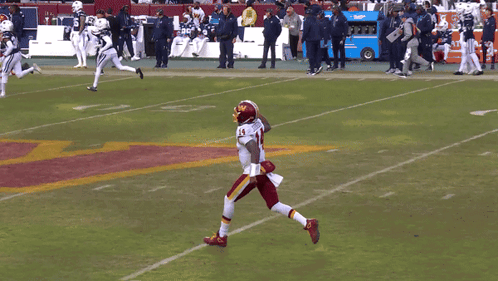 A Football Player With The Number 14 On His Jersey Stands On The Field GIF