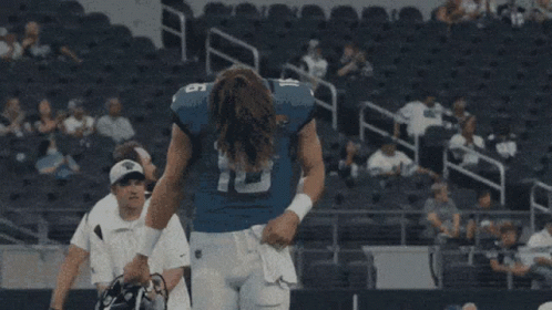 A Football Player With The Number 16 On His Jersey Stands In A Stadium GIF