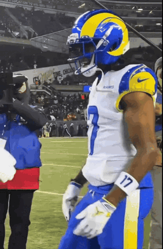 a football player with the number 17 on his arm stands on the field