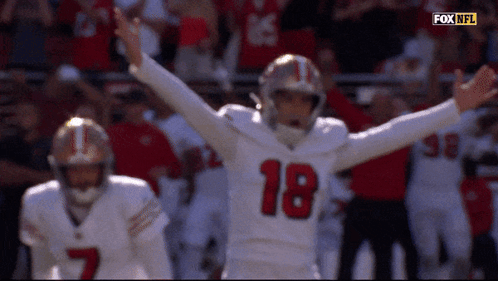 a football player with the number 18 on his jersey is celebrating