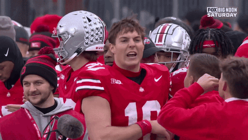 A Football Player With The Number 18 On His Jersey Is Surrounded By Other Players GIF