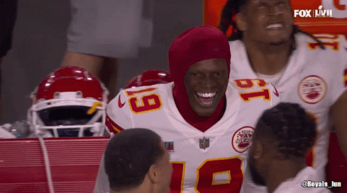 A Football Player With The Number 18 On His Jersey Smiles With His Teammates GIF