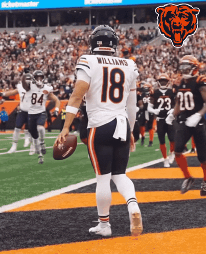 a football player with the number 18 on his jersey stands on the field