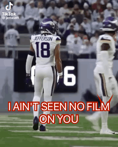 A Football Player With The Number 18 On His Jersey Walks On The Field . GIF