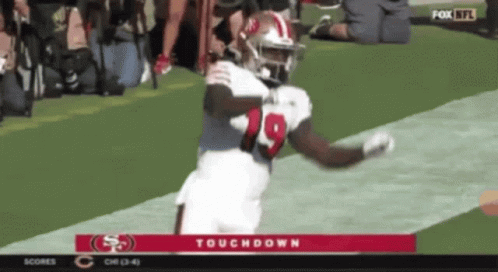 A Football Player With The Number 19 On His Jersey Is Running On The Field GIF