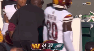 A Football Player With The Number 20 On His Jersey Is Being Helped By A Man GIF