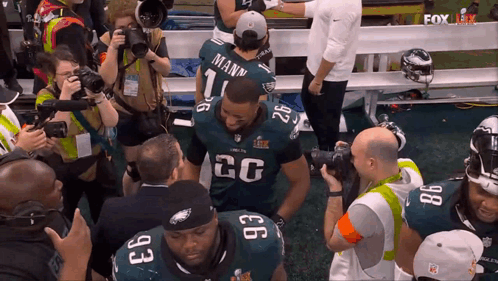 A Football Player With The Number 26 On His Jersey Is Surrounded By Other Players GIF