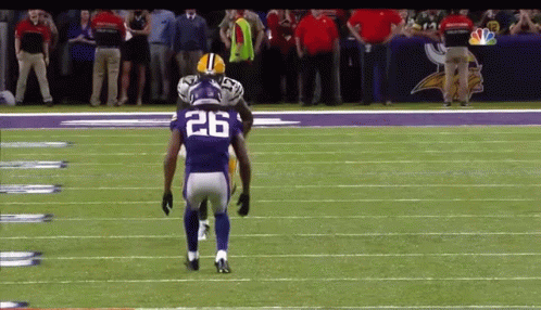 A Football Player With The Number 26 On His Jersey Stands On The Field GIF