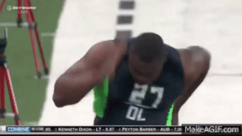 A Football Player With The Number 27 On His Jersey Stands On The Field GIF