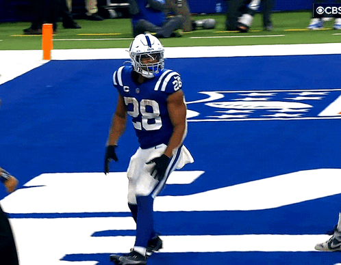 A Football Player With The Number 28 On His Jersey Walks Across The Field GIF