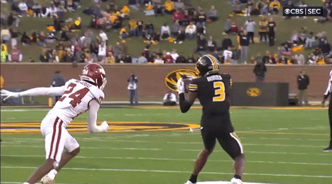 a football player with the number 3 on his jersey is trying to catch a pass from another player