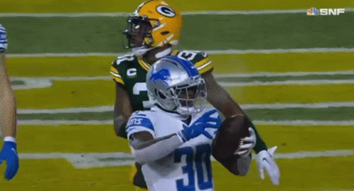 A Football Player With The Number 30 On His Jersey Is Trying To Catch A Ball . GIF