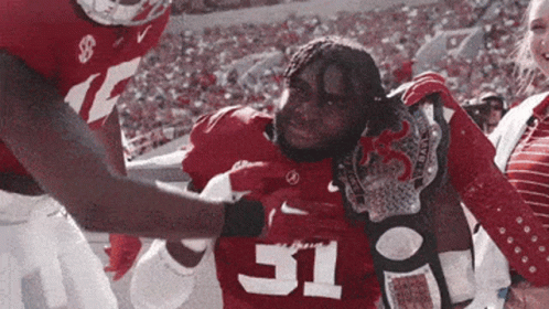 A Football Player With The Number 31 On His Jersey Is Being Helped Off The Field GIF