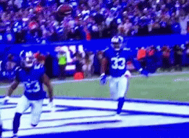 A Football Player With The Number 33 On His Jersey Is Running On The Field . GIF
