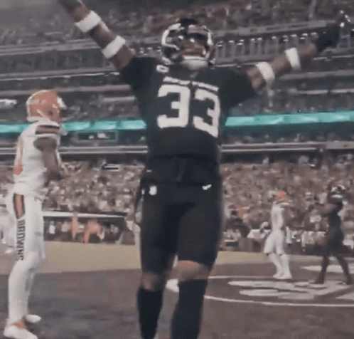 A Football Player With The Number 33 On His Jersey Stands On The Field GIF
